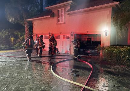 Firefighters assess damage outside home struck by lightning