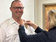Assistant Chief Corn pinned with new collar brass by wife, Kelli