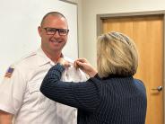 Assistant Chief Corn pinned with new badge by wife, Kelli